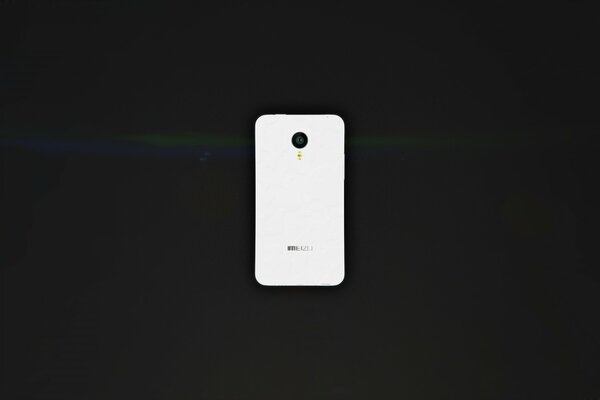 A white smartphone on a black table