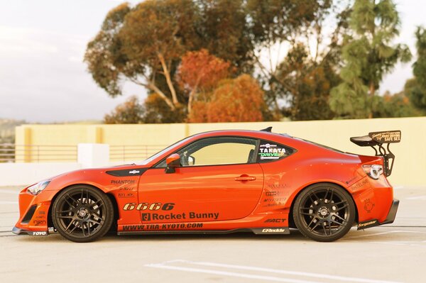 An orange sports car is on the road