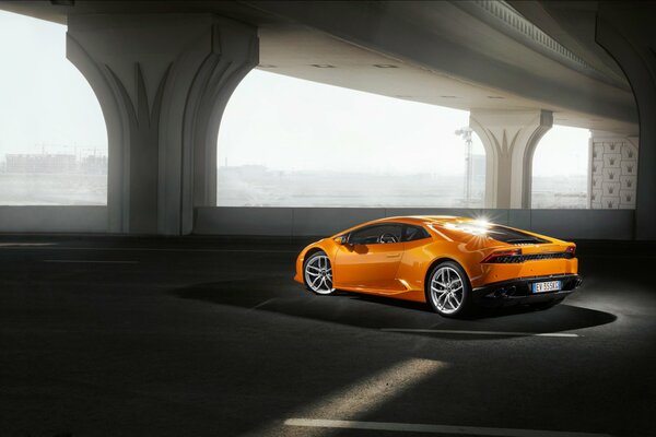 An orange lamborghini is parked in the parking lot