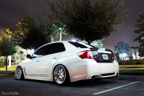 White Subaru impreza in the lights of the night city