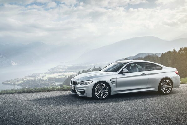 A silver car is standing at the cliff