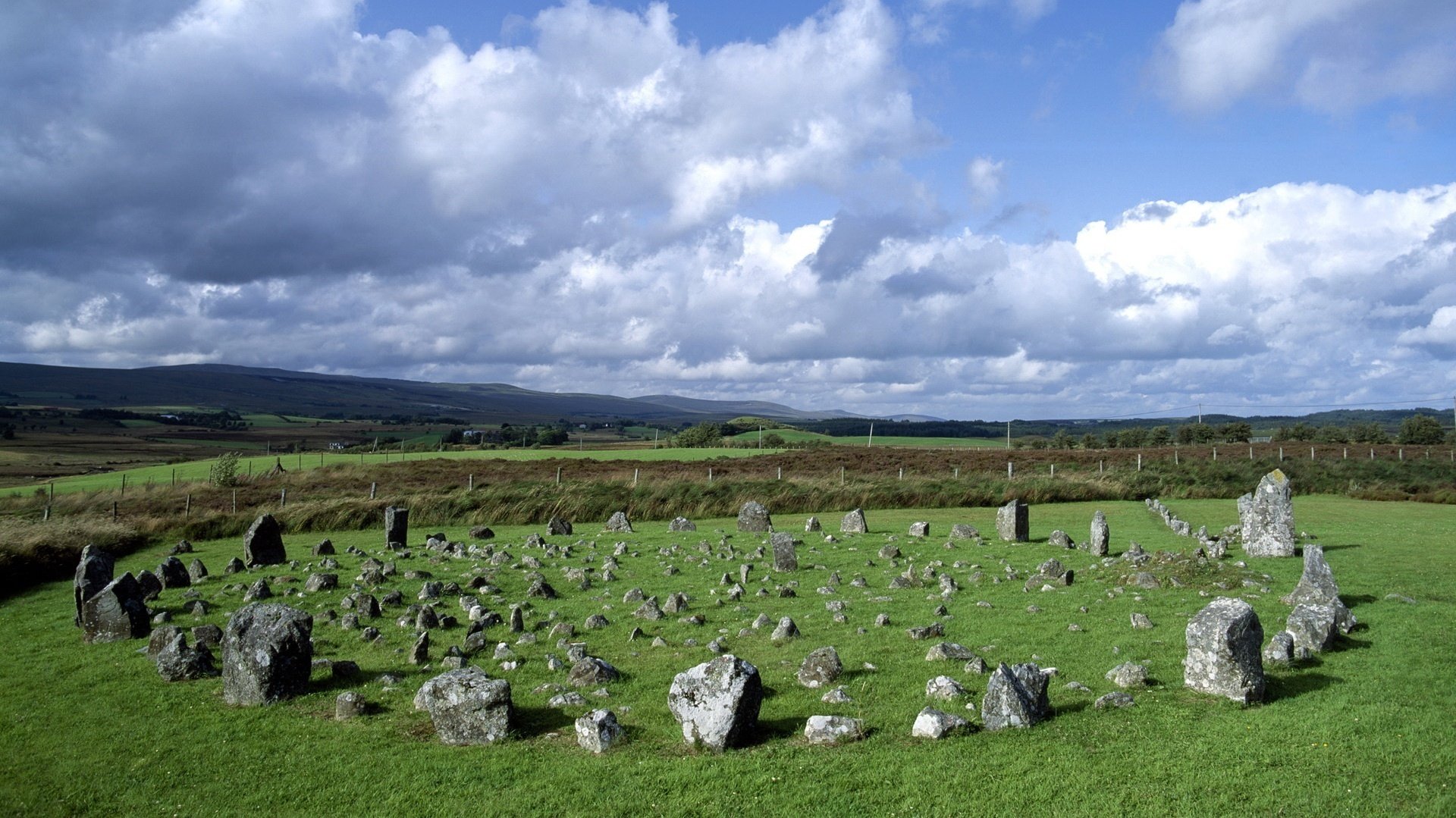 tone circle pieces of stone clearing the sky clouds round fence nature greens summer meadow