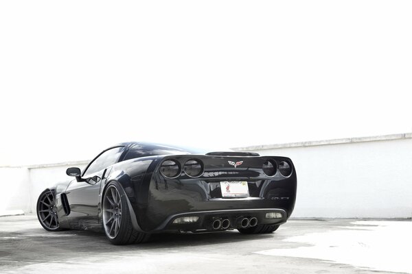 Black Chevrolet corvette car on a background of white walls
