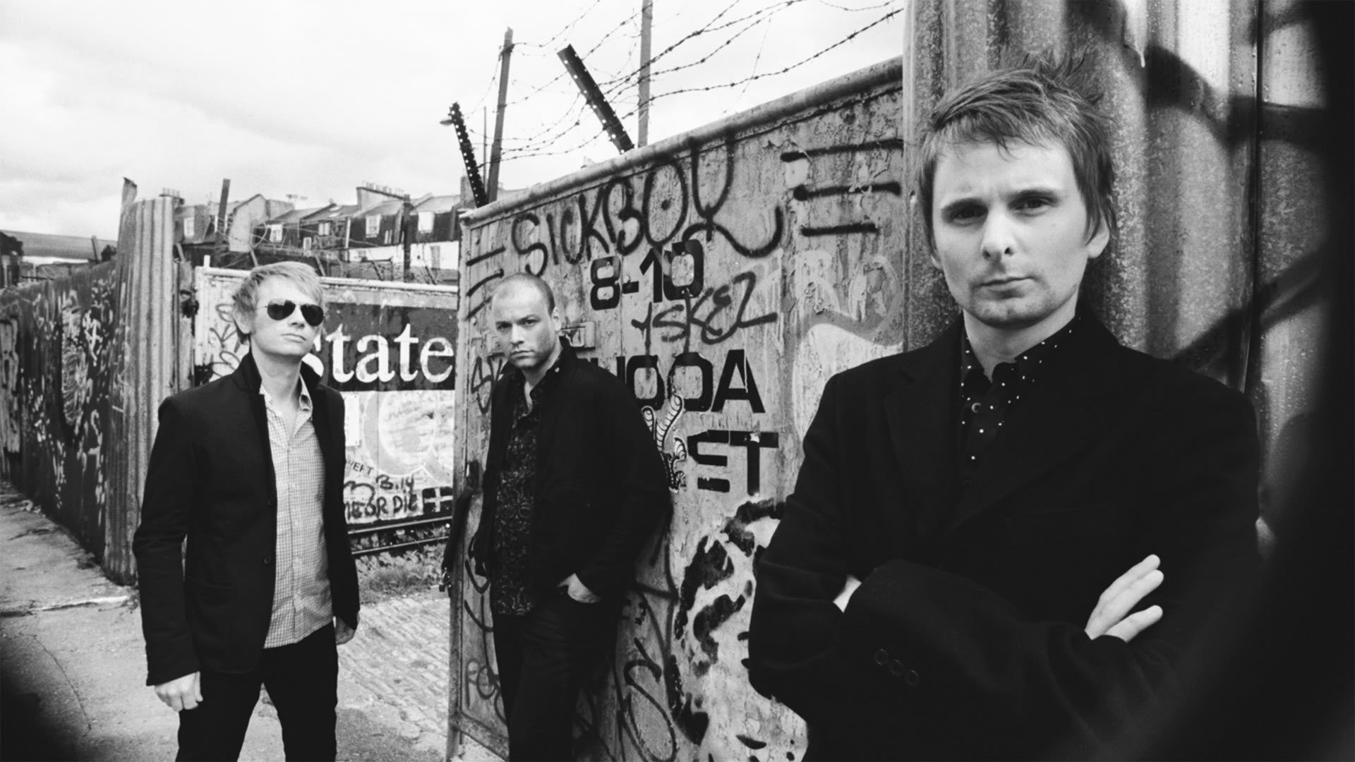 painted wall graffiti stylish guys music group the team b-b glasses trio wire wall fence face black and white