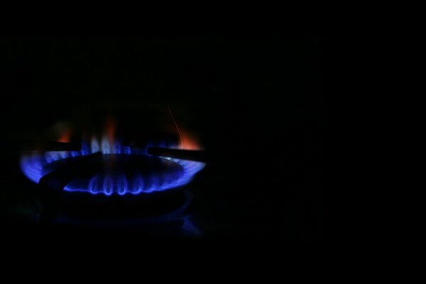 Gas burner on a black background. Blue and red flames