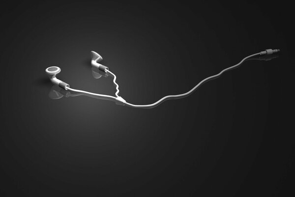White headphones lie on a mirrored gray background