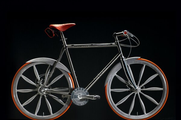 A silver bicycle stands on a black background