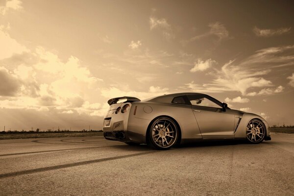 Gray Nissan on a light sky background