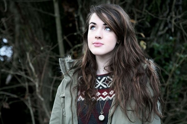 A cute girl with gray eyes looks into the distance