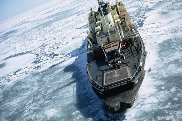 A ship in the Arctic on an ice floe in the middle of the water