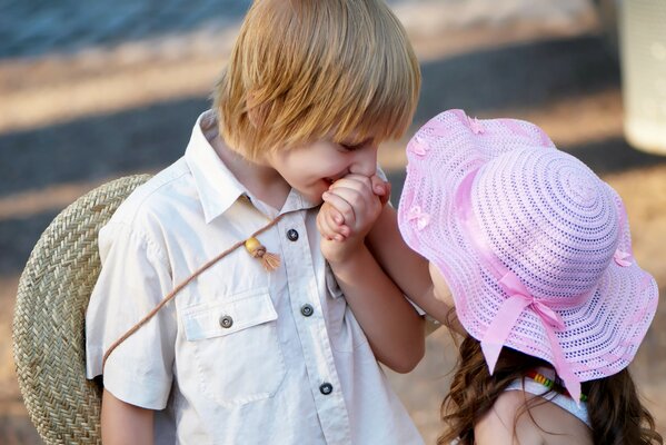 A gentle boy kisses a girl s hand