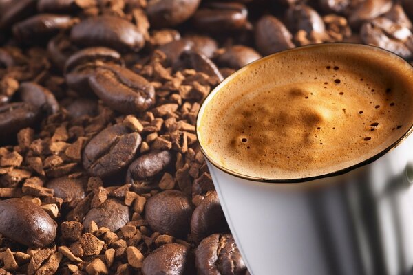 A cup of coffee with foam on the beans