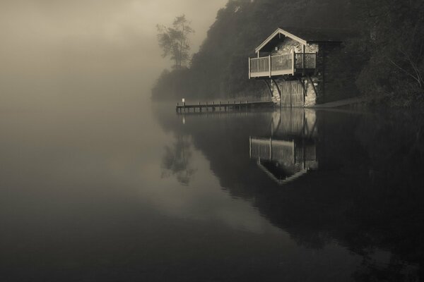 Lake in the fog with a lonely house
