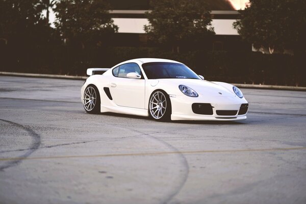 White Porsche on grey asphalt