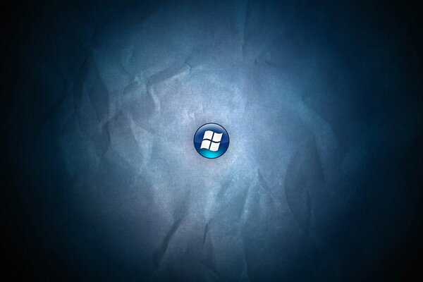 Windows logo on a blue button on a background of crumpled paper