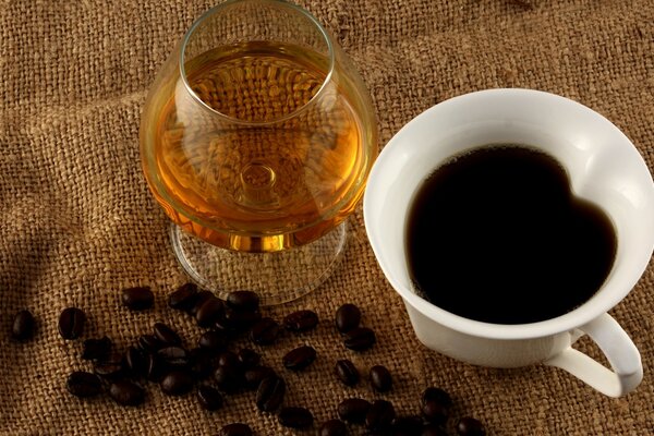 A glass of cognac and coffee on burlap