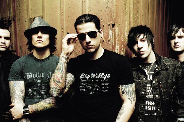 The soloists of the rock band are standing near the wall