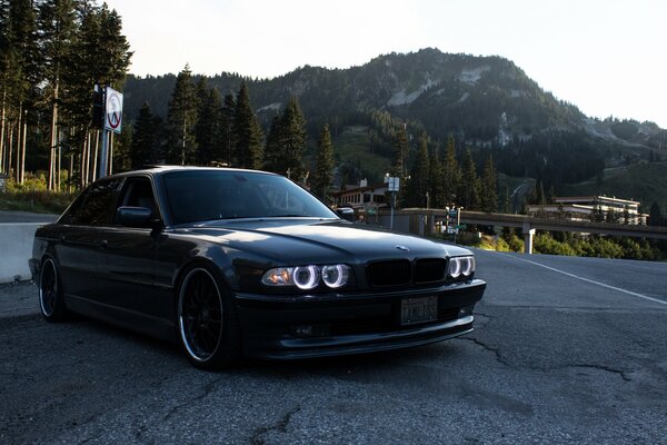 Black BMW on the road against the background of mountains