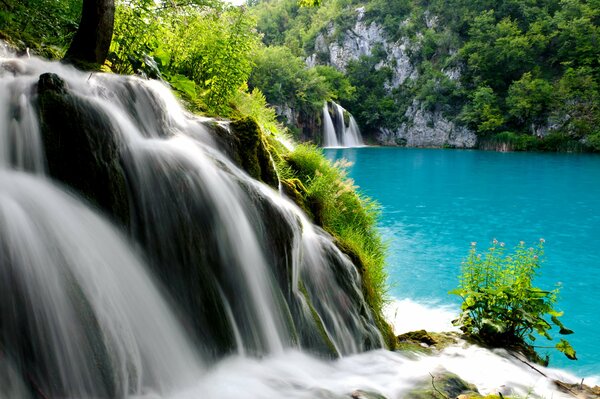 Mountain waterfall flowing into the blue lake