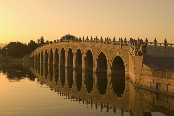Architectural bridge across the river at sunset