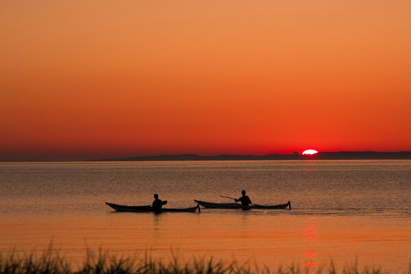 Boats on the background of sunset, reeds