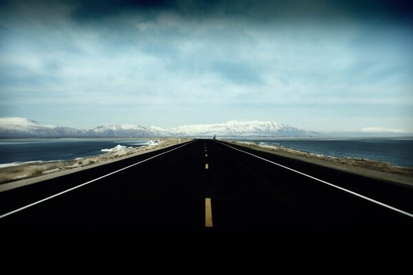 The black road leading into the blue distance