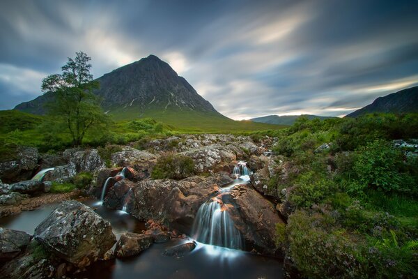 Beautiful landscape of Scotland with a river and a waterfall
