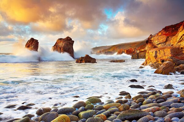 At the shore of the waves at sunset