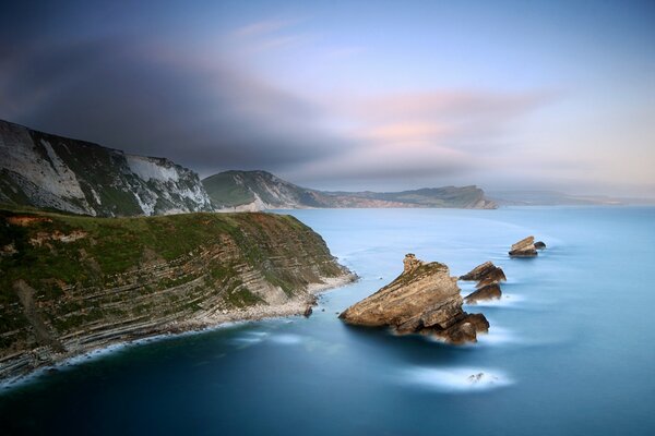 Rocks in the sea against a haze at dusk
