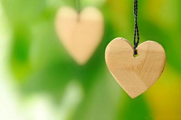 Wooden hearts on a string on a green background