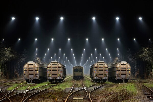 Night railway cars among the searchlights