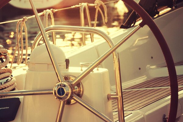 The steering wheel of the yacht on the sunny pier