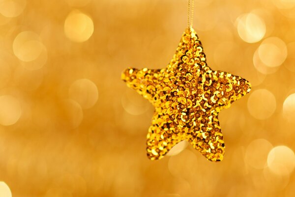 Golden shiny Christmas tree toy in the shape of a star