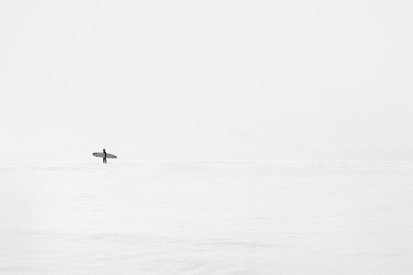 A man with a board in the clear sea