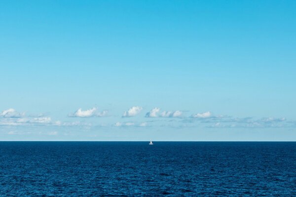 The sail is white, lonely in the blue sea fog