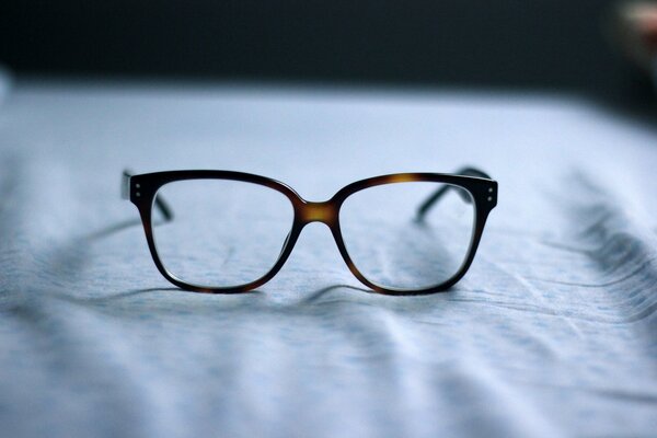 Dark-framed glasses on light fabric