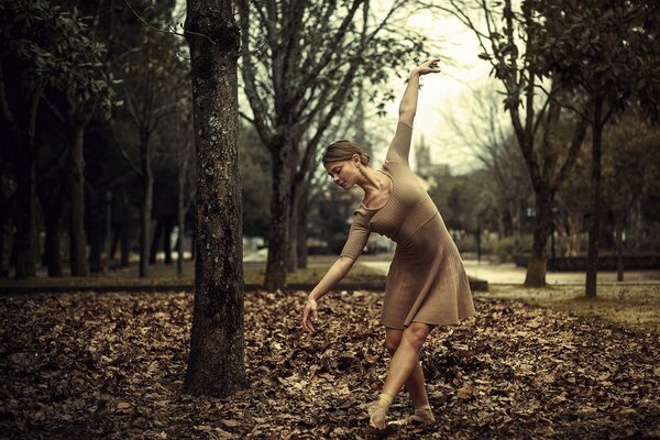 Girl dancing on autumn leaves