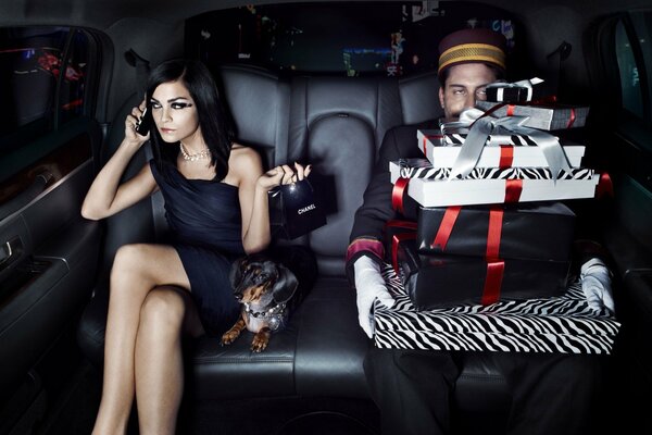 A girl and a guy in a car with a dog