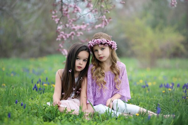 Two girls are sitting on the grass