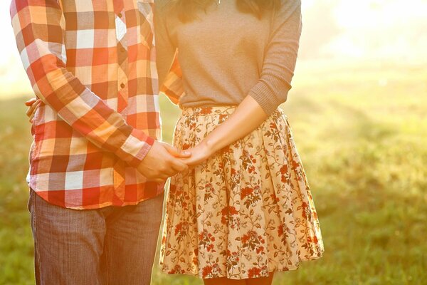 A man and a woman in love hugging a couple without a face on the background of meadow grass