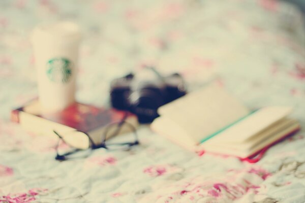 There is a book glasses and a glass on the table