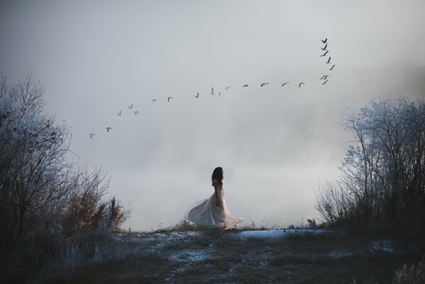 The girl spends autumn with a flock of birds