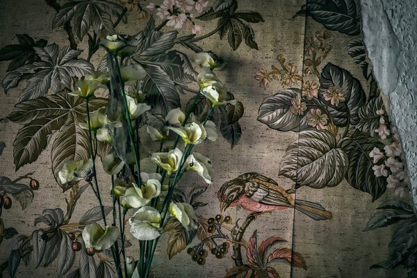Kaala flowers on a background of floral wallpaper