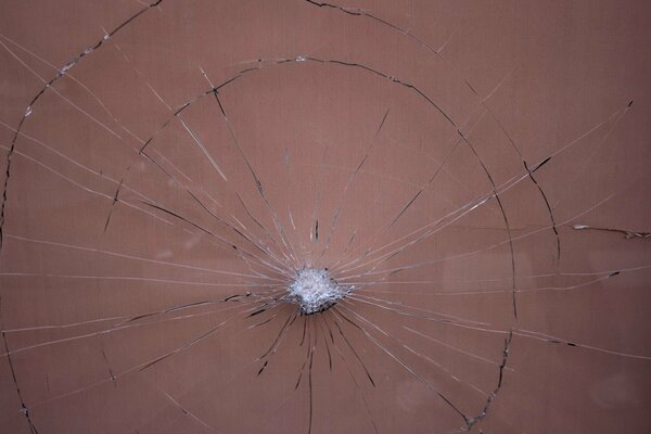 Broken glass with a stuck stone in the middle