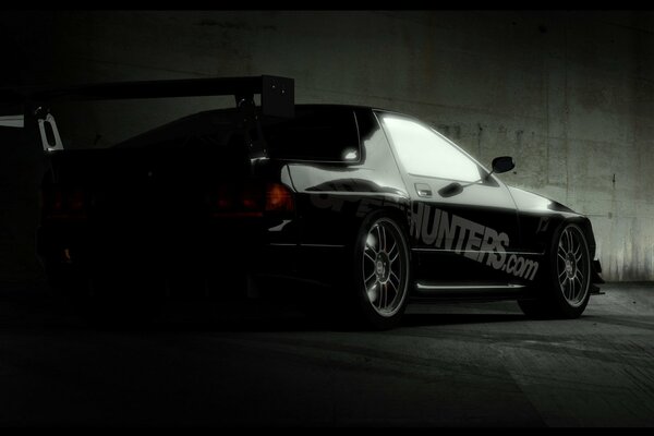 A tuned black Honda car on a dark background