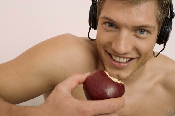 Guy with headphones eating an apple