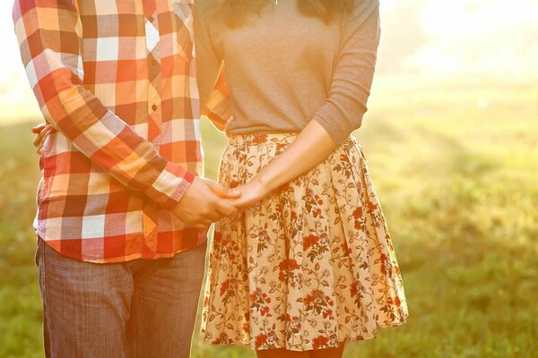 A couple in love holding hands against the background of nature