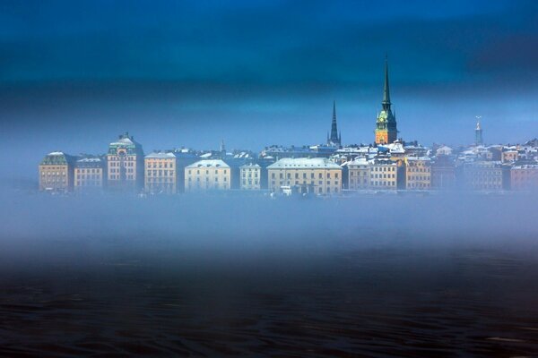 The city is in a fog and the roofs are visible