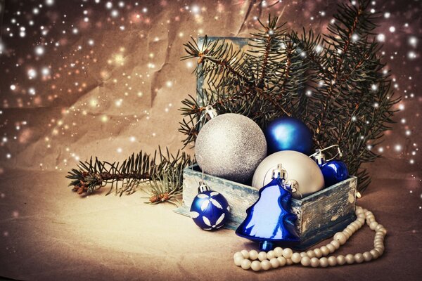 A box with Christmas balls and a string of pearl beads