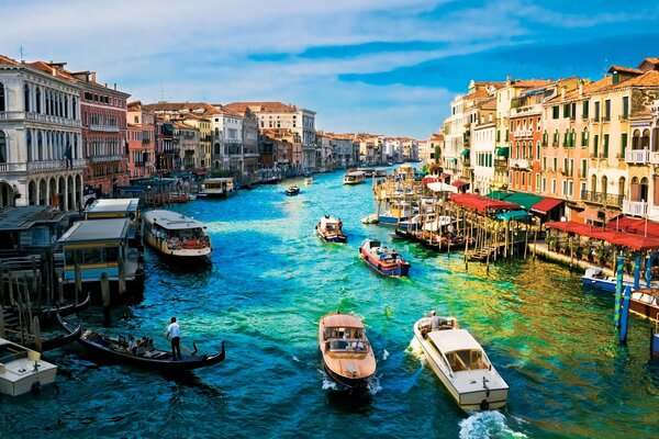 Boats and speedboats in the Venice River. Beautiful houses and a bright landscape